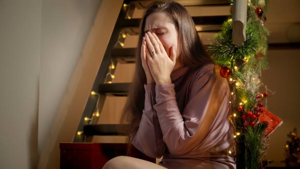 istock Young woman got upset and started crying during Christmas or New Year. Negative emotions, depression and solitude on celebrations. 1802354792