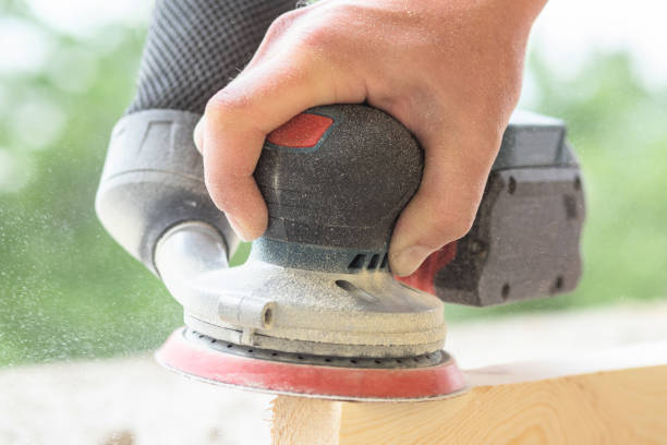istock An eccentric sander in the hands of a worker grinds a wooden surface, close-up 1802356437