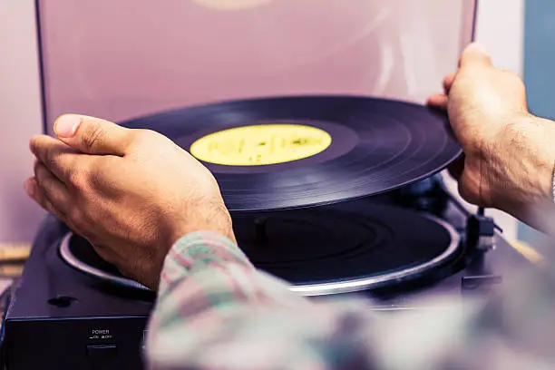 Photo of Hands placing record on turntable