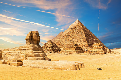 The Sphinx next to the Pyramids in the sands of Giza desert, Egypt.