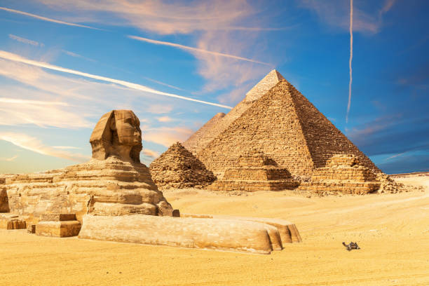 The Sphinx next to the Pyramids in the sands of Giza desert, Egypt The Sphinx next to the Pyramids in the sands of Giza desert, Egypt. great pyramid of khufu stock pictures, royalty-free photos & images