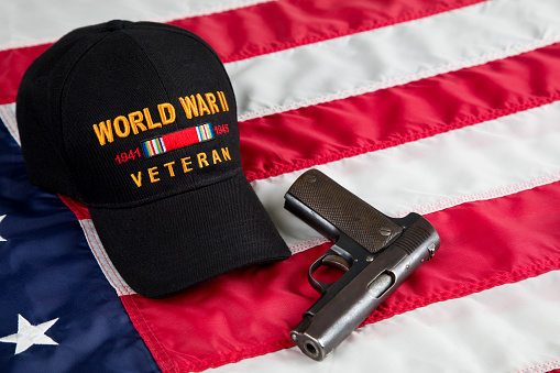 United States Second Amendment constitutional Right to Bear Arms. Antique firearm and veterans cap resting on an American Flag.