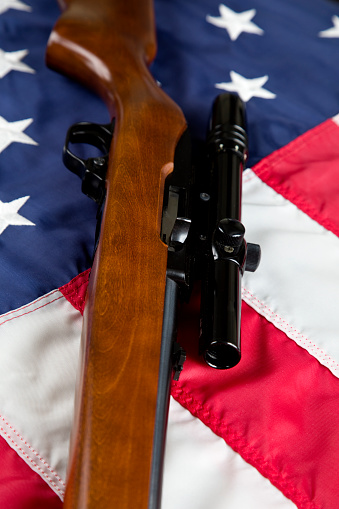 U.S. Second Amendment constitutional Right to Bear Arms. semi automatic rifle resting on American Flag.