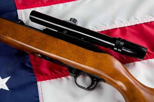 U.S. Second Amendment constitutional Right to Bear Arms. semi automatic rifle resting on American Flag.