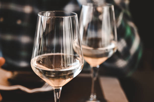 istock Close up of two glasses with white wine. 1802403204