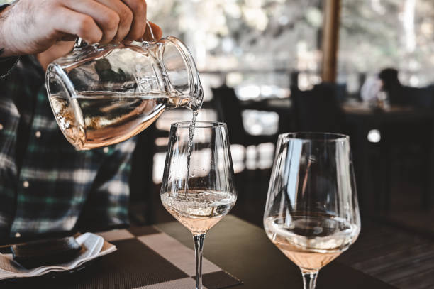 istock pouring white wine into glasses. 1802403207