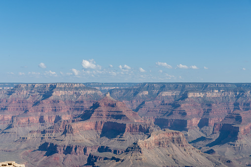 The Grand Canyon as seen from Mather Point on the South Rim of the canyon. Morning light shows the colored striations in the rock of the canyon walls and white clouds begin to gather on the horizon.