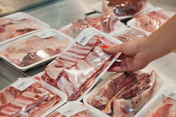 istock Woman's hand inspecting various packages of meat 180241510