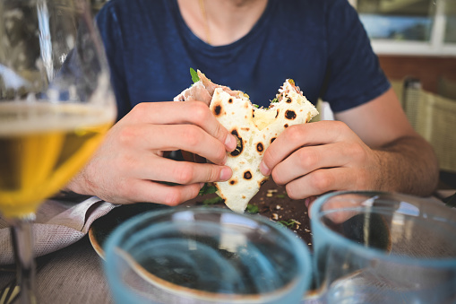man eating piadina in a restaurant.