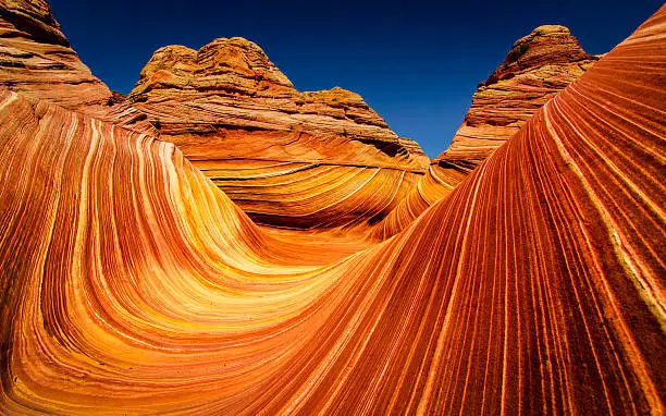 The Wave is a sandstone rock formation. It is located near the Arizona-Utah border, on the slopes of the Coyote Buttes, in the Paria Canyon-Vermilion Cliffs Wilderness, on the Colorado Plateau. It is famous among hikers and photographers for its colorful, undulating forms, and the rugged, trackless hike required to reach it.