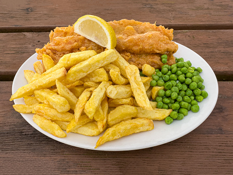 Classic dinner of fish and chips with peas