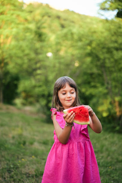 istock joyful girl eating ripe watermelon. 1802437104