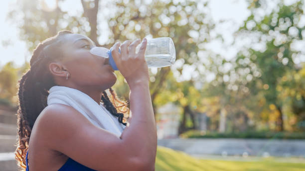 istock A woman drinking water after workout at home 1802438700