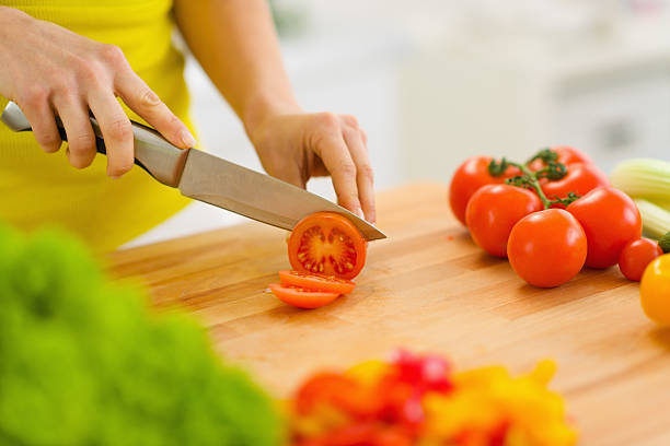 istock Closeup on woman cutting tomato 180245084