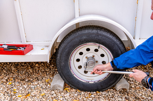 Defocused car mechanic listening customer in the auto repair shop. Focus on wheel.