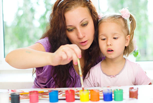 istock Child with mother painting 180247826