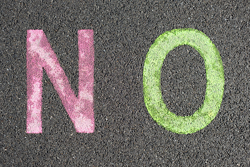 NO stenciled in pavement paint on the wet asphalt