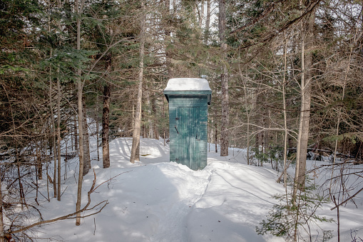 An outside toilet in the wood in winter taken on a sunny winter day in Mont Tremblant, Quebec, Canada