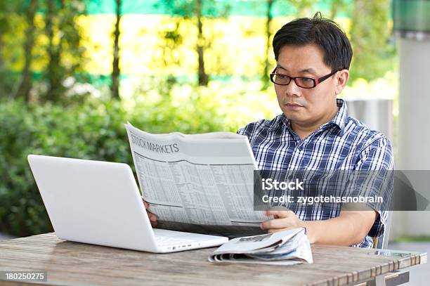 Азиатский Мужчина Чтение Финансовой Газеты С Белый Ноутбук — стоковые фотографии и другие картинки Беспроводная технология