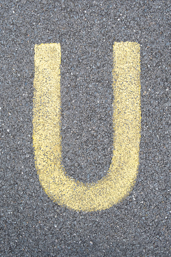 The Letter U is drawn with color paint on asphalt. a children's playground designed a creative display of the alphabet educational element learning space.