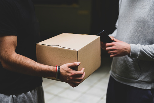 close up of delivery man and package giving to a customer.