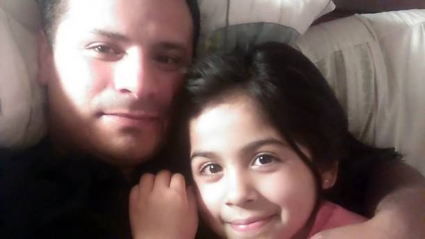 father and daughter take a selfie while resting on a sofa