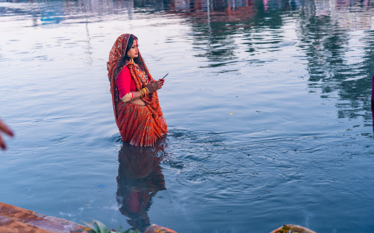 An ancient Hindu festival, dedicated to Lord Surya and Chhathi, A devotee offers prayers to the setting sun during the “Chhath” festival at Bagmati River  in Kathmandu, Nepal, on  Sunday November 19, 2023