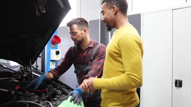 Mechanic is talking to the customer about a problem with the car