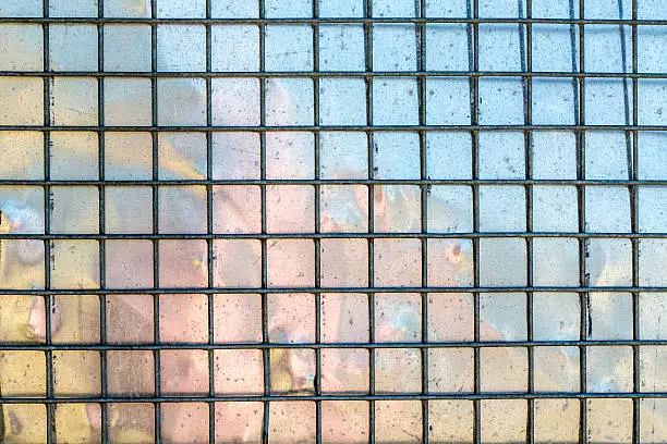 metal grid with mirroring surface in background,