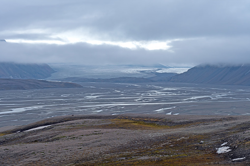 Distant Glacier Brooding in the Fog Over Its Glacial Valley at Lomfjorden in the Svalbard Islands