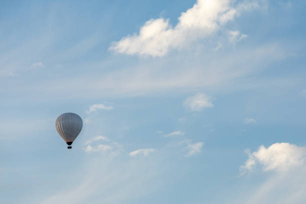 istock Hot air balloon silhouette in blue sky with white clouds. Photo from below 1802576340