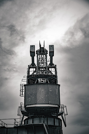 an industrial crane at the harbor with a view from below in black and white