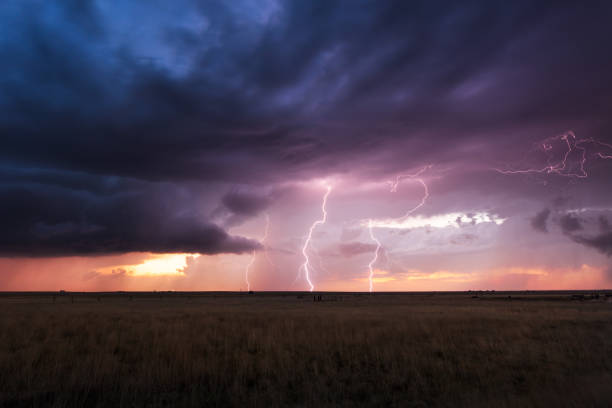 istock Thunderstorm lightning bolts at sunset 1802594132