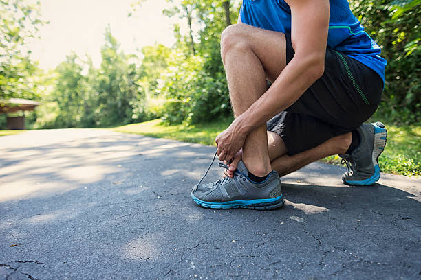 istock Young Man Tying His Sports Shoelace 180259622