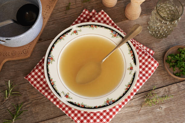 istock Chicken soup or bone broth in a plate on a table, top view 1802596284