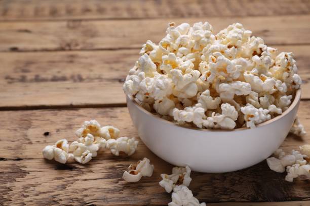 istock Tasty popcorn on wooden table, closeup. Space for text 1802626035