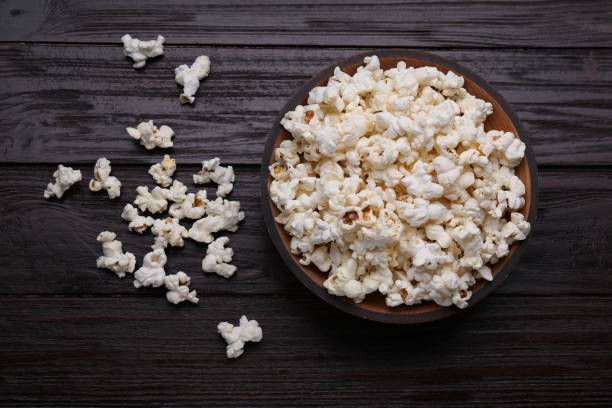 istock Tasty popcorn on black wooden table, flat lay 1802628198