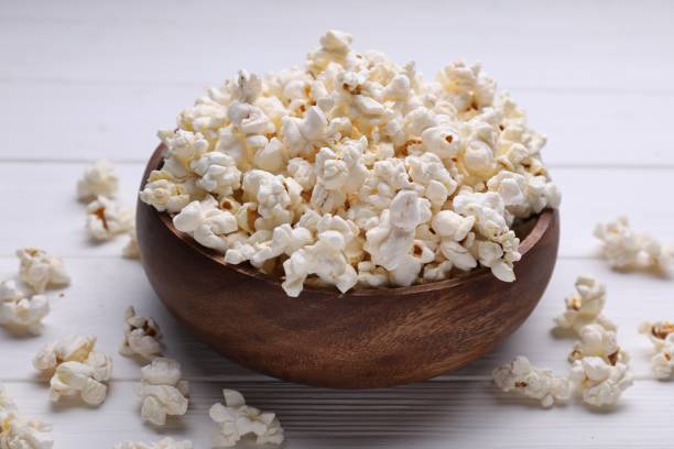 istock Tasty popcorn on white wooden table, closeup 1802628745