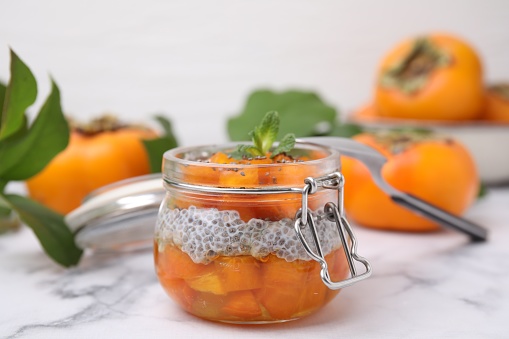 Delicious dessert with persimmon and chia seeds on table