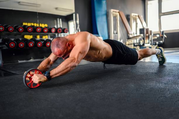 istock Man do abdominal exercises with wheel 1802656505
