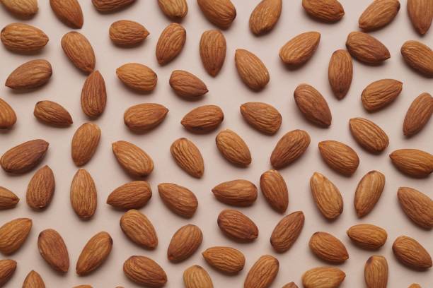 istock Delicious raw almonds on beige background, flat lay 1802669852