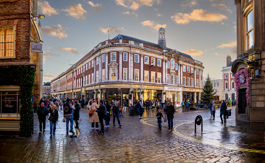 St Helens Square, York, UK - November 17, 2023.  Shoppers and crowds of people walking through York city centre at Christmas with Betty's Cafe and Tea Room building at sunset