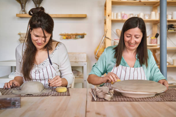 istock Two women with apron making pottery crafts in a workshop. 1802672567