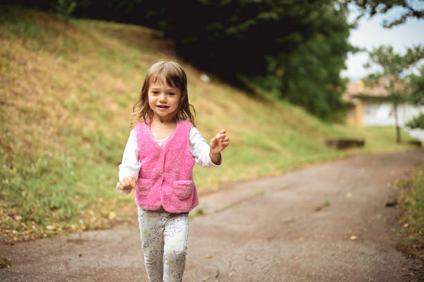 istock cute child running on a road in a park. 1802674721