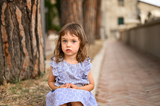 portrait of two years old child girl on urban street.