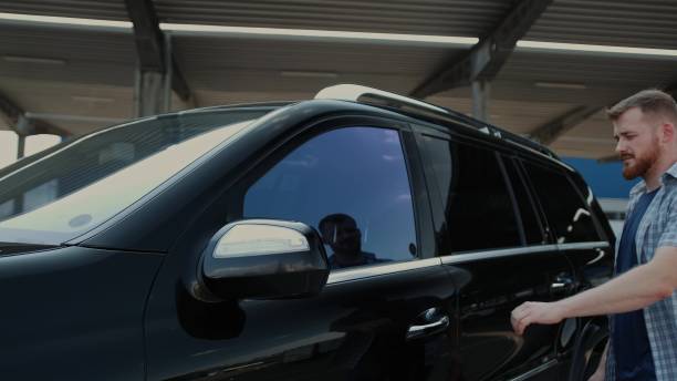 istock Young man open car door, sitting at driver seat. Slow motion 1802680111