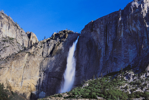 Panoramic view of famous Yosemite Valley with beautiful Merced river on a scenic sunny day with blue sky in summer, Yosemite National Park, California, USA