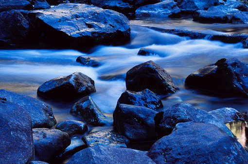 Mountain river cascading over granite river rocks, showing motion.\n\nTaken in Yosemite National Park, California, USA