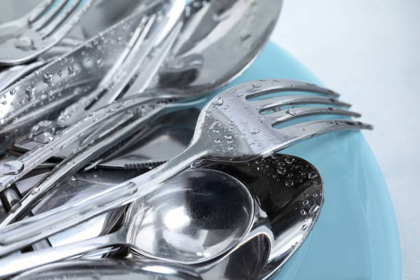 istock Washing silver spoons, forks and knives with plate, closeup 1802705106