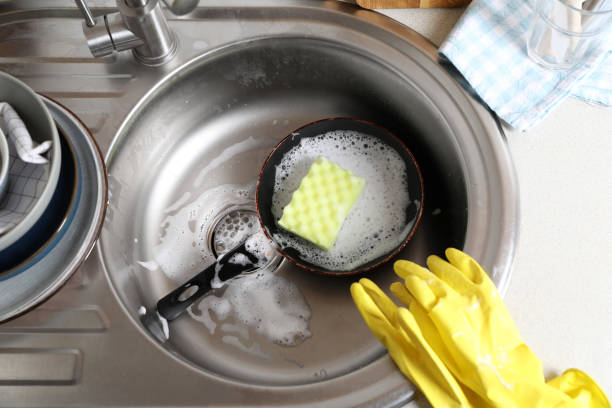 istock Dirty frying pan with sponge in kitchen sink, above view 1802707439